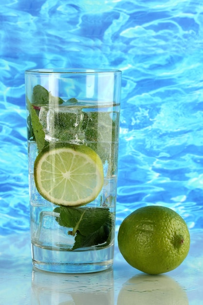 Foto copo de água com gelo hortelã e limão no fundo do mar