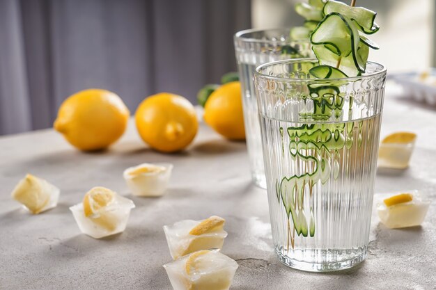 Copo de água de pepino fresco na mesa cinza