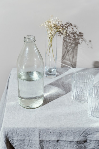 Foto copo de água e vaso com flores