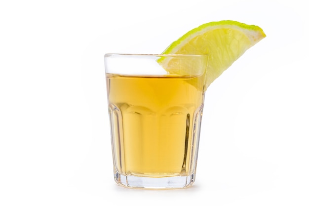 Copo de bebida alcoólica com limão, destilada da cana-de-açúcar, chamada no Brasil de "pinga" ou "cachaça", em fundo branco isolado