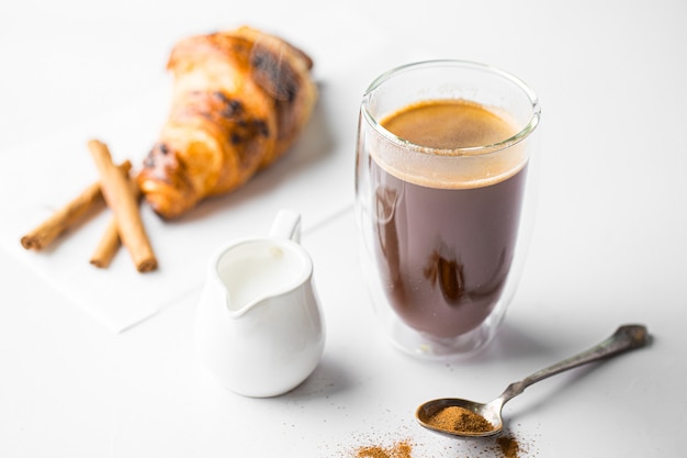 Copo de café com leite com croissant branco