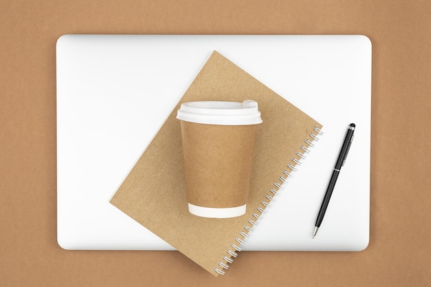 Copo de café de papel artesanal com capa de papel reciclado para notebook e laptop flat lay