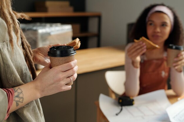 Foto copo de café descartável segurado por uma mulher