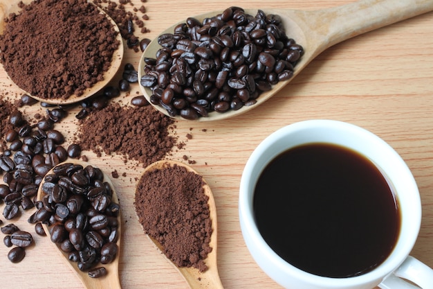 Copo de café e feijões de café na tabela de madeira.