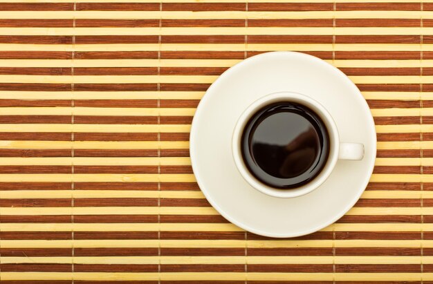 Foto copo de café em cima de uma mesa de bambu