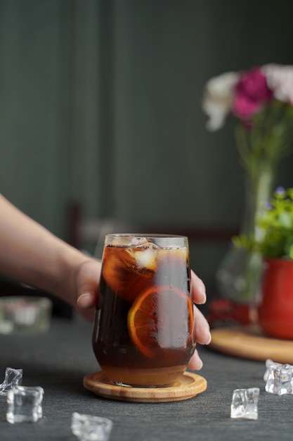 Copo de café expresso com suco de limão e fatias de limão fresco na mesa de madeira