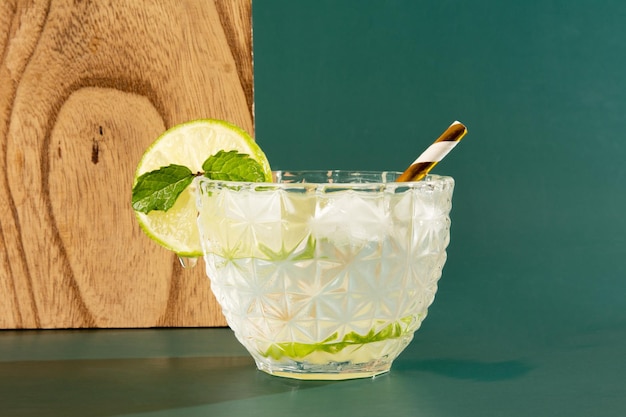 Copo de Caipirinha de Pinga Cocktail com Limão em um fundo verde liso na foto da frente