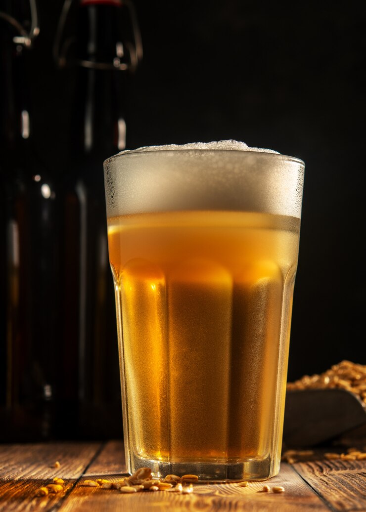 Copo de cerveja caseira em uma mesa de madeira. Copo de cerveja artesanal em um fundo escuro.