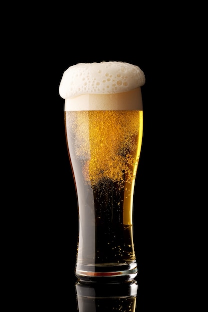 Copo de cerveja com bolhas e espuma espessa branca, isolado em fundo preto