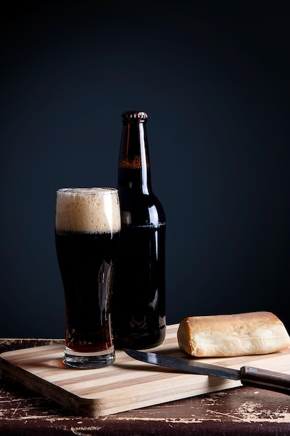 Copo de cerveja e garrafa com queijo na mesa