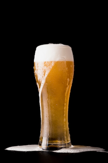 Copo de cerveja em frente a um fundo preto