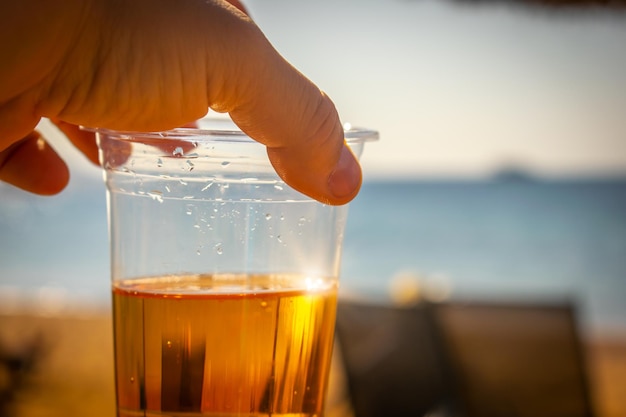 Copo de cerveja em um dia quente na praia, conceito de férias em família, praia exótica do Mar Vermelho Aqaba Jordan