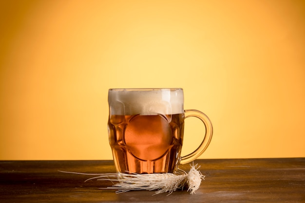 Foto copo de cerveja light com espiga de cevada na mesa de madeira