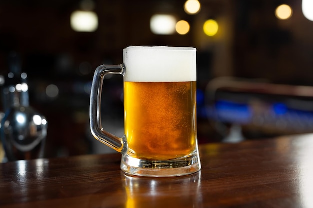 Foto copo de cerveja light em um pub escuro