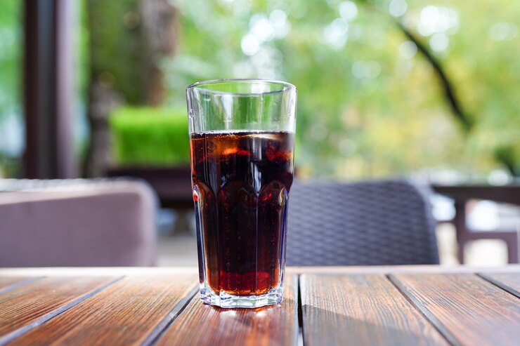 Copo de cerveja preta na mesa de madeira de um restaurante