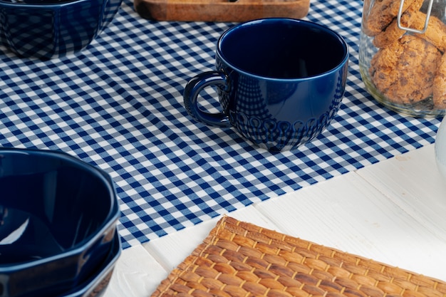 Copo de chá cerâmico vazio azul clássico na mesa da cozinha close-up