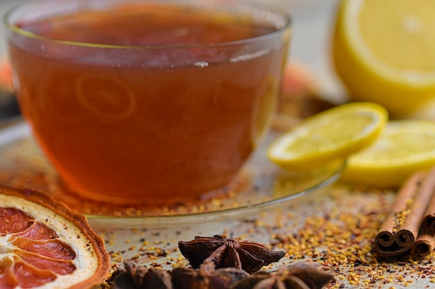 Foto copo de chá com pauzinhos de canela em mesa de madeira fundo pauzinho de canela estrela anis limão