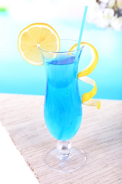 Foto copo de coquetel na mesa sobre fundo azul claro