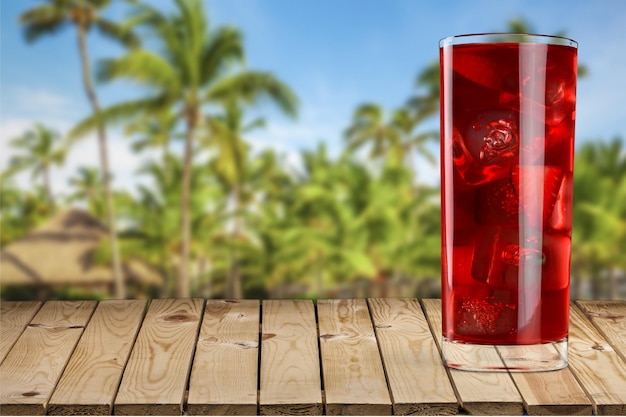 Copo de coquetel vermelho na mesa de madeira