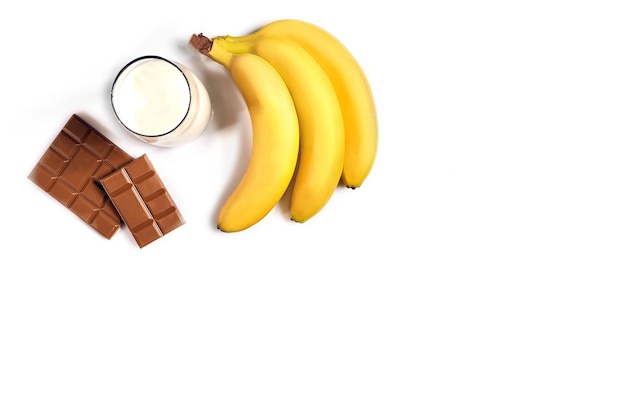 Foto copo de leite com banana e chocolate na vista superior de fundo branco