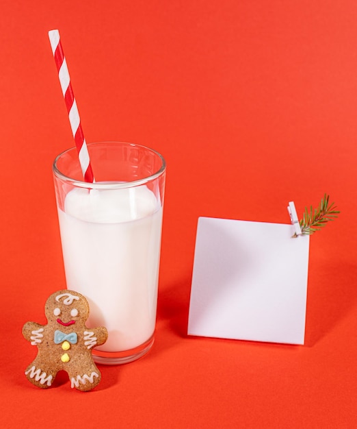Copo de leite com homem de gengibre de palha e nota branca vazia no leite vermelho para Santa Mock up