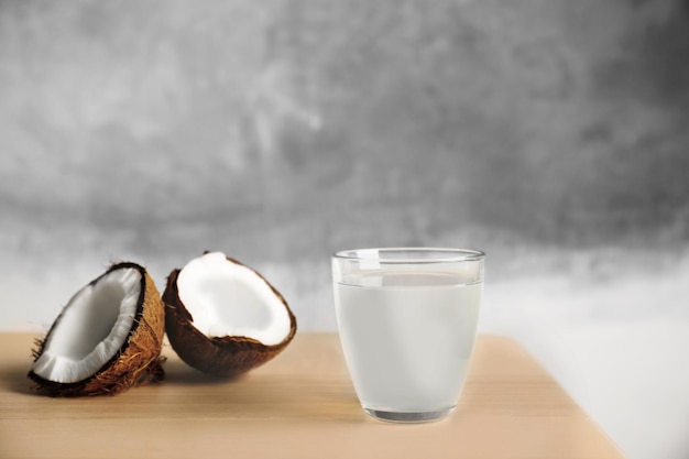Copo de leite de coco e nozes na mesa de madeira