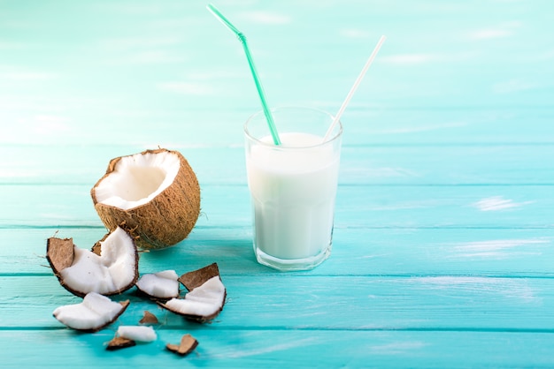 Copo de leite de coco na mesa de madeira azul