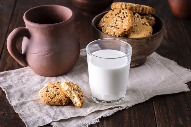 Copo de leite e biscoitos na mesa de madeira