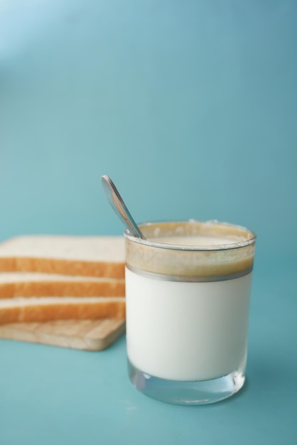 Copo de leite e pães na mesa