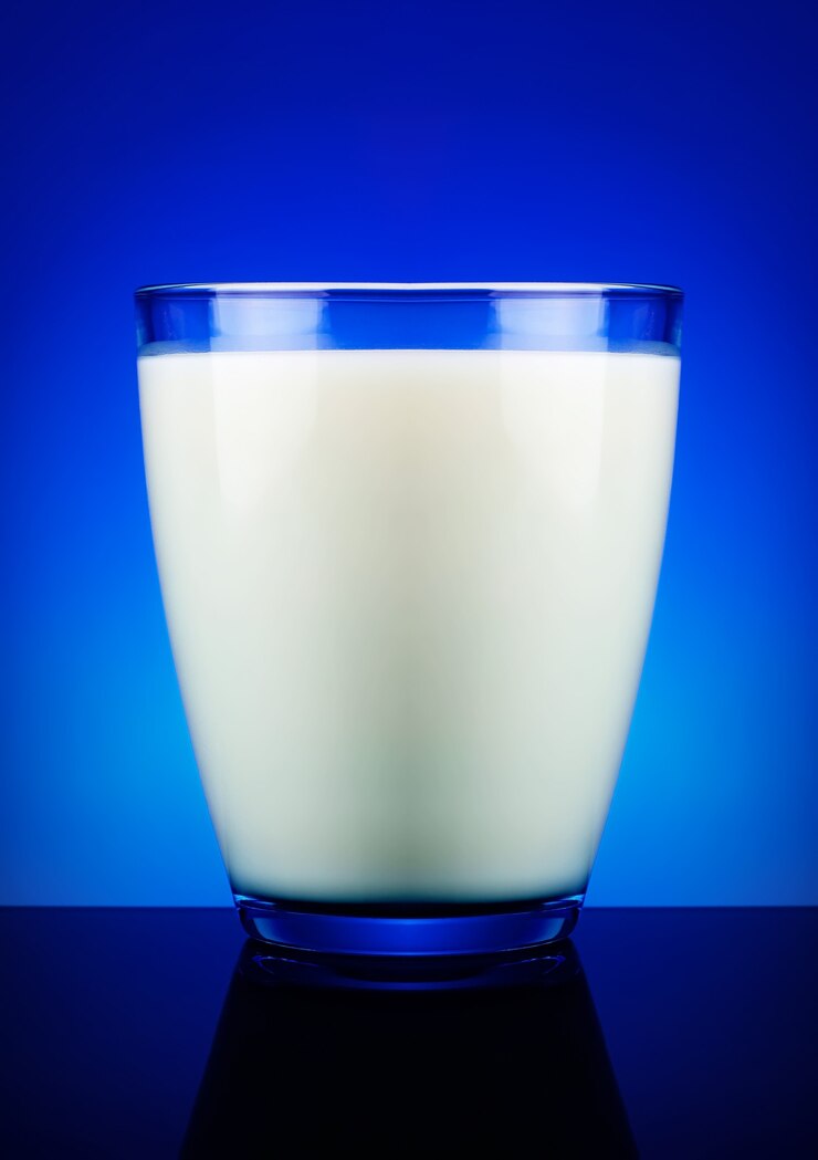 Foto copo de leite e superfície azul