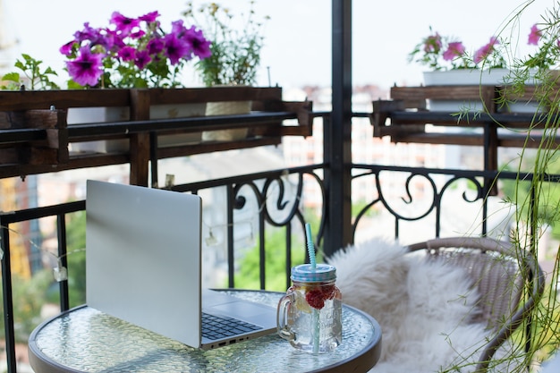 Copo de limonada e vista de flores e trabalhando em casa