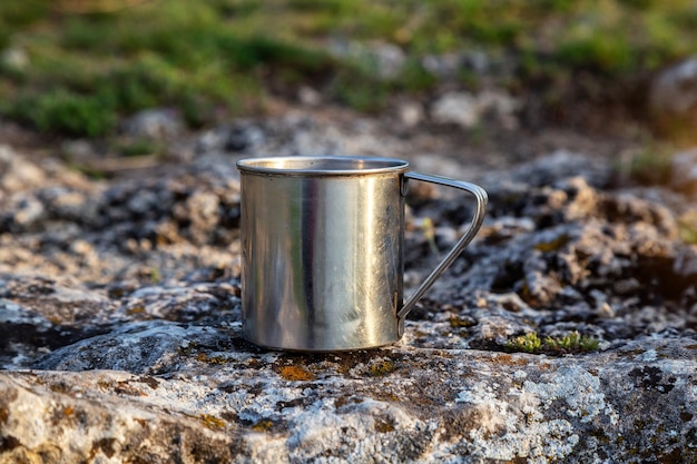 Copo de metal na natureza Fazendo café Acampamento e férias de verão