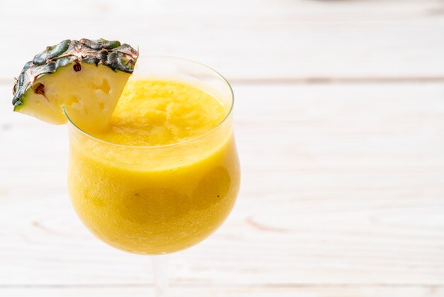 Foto copo de suco de abacaxi fresco na mesa de madeira