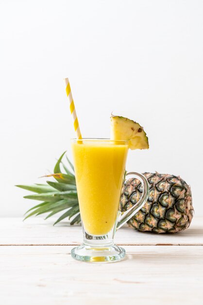 Copo de suco de abacaxi fresco na mesa de madeira