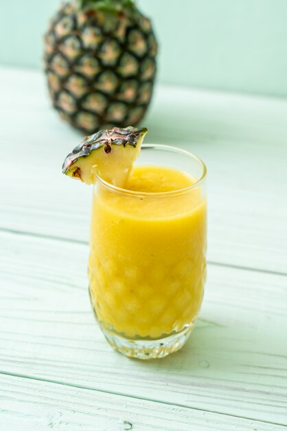 copo de suco de abacaxi fresco na mesa de madeira