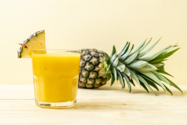 Foto copo de suco de abacaxi fresco na mesa de madeira