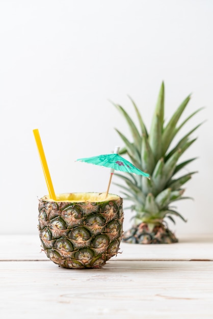 Foto copo de suco de abacaxi fresco na mesa de madeira