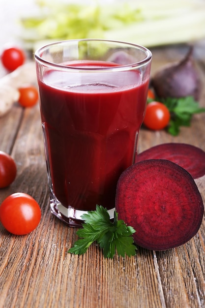 Copo de suco de beterraba com legumes na mesa de madeira fechar