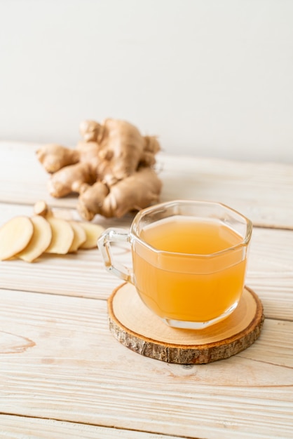 Copo de suco de gengibre fresco e quente com raízes de gengibre - estilo de bebida saudável