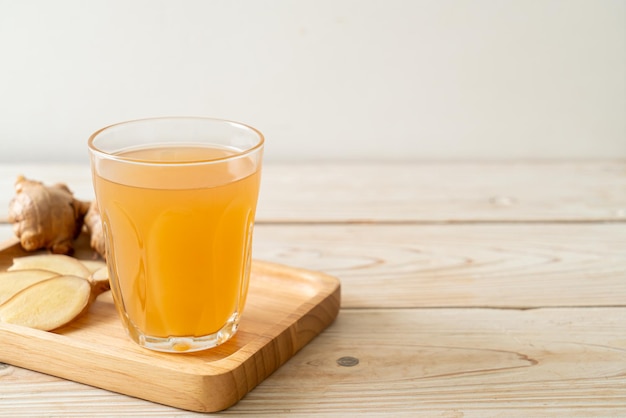 copo de suco de gengibre fresco e quente com raízes de gengibre - estilo de bebida saudável