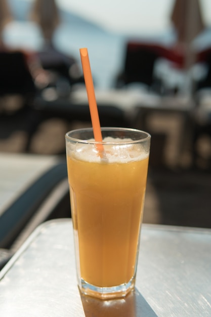 Copo de suco de laranja com canudo