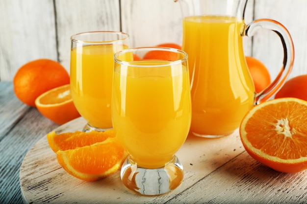 Copo de suco de laranja com fatias na cor de fundo de madeira