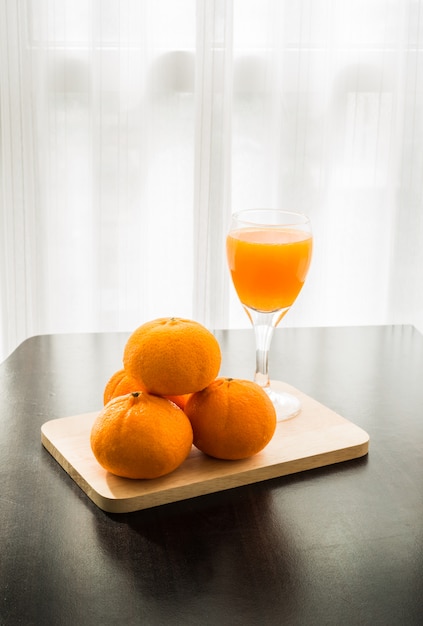 Copo de suco de laranja espremido na hora com quatro laranjas