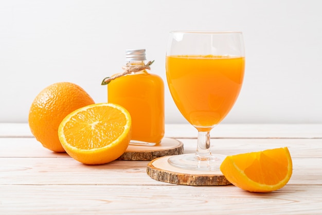 Copo de suco de laranja fresco com fundo de madeira