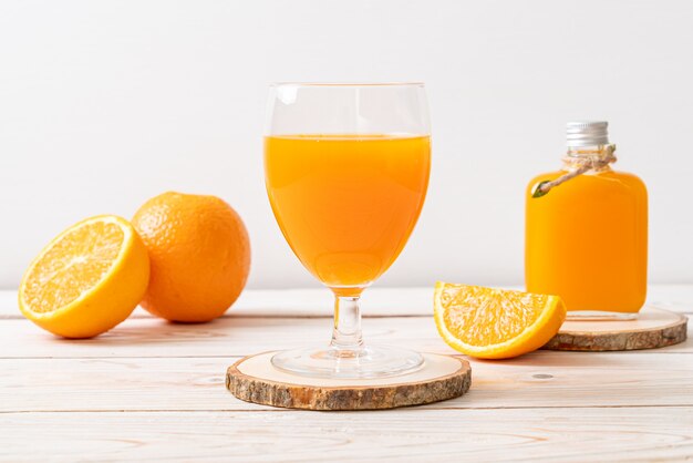 Copo de suco de laranja fresco com laranjas