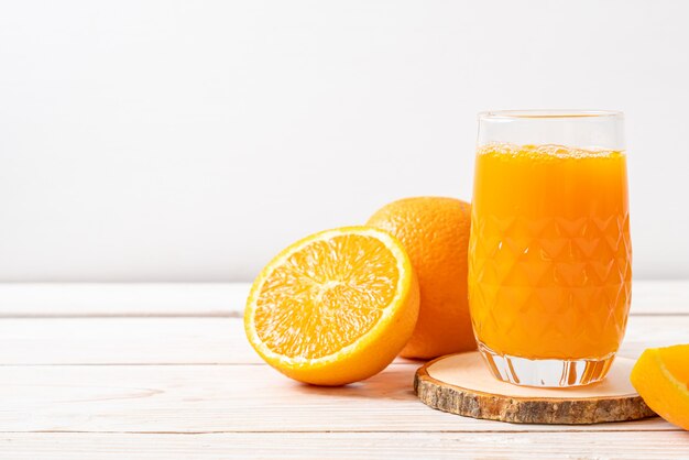 Copo de suco de laranja fresco com laranjas