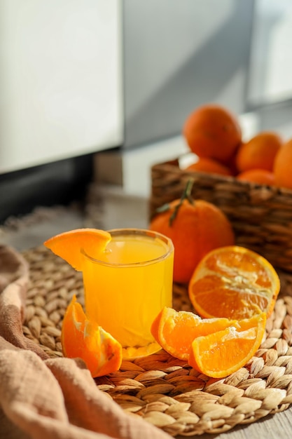 Copo de suco de laranja laranjas fatiadas e uma cesta de laranjas As laranjas são brilhantes e frescas