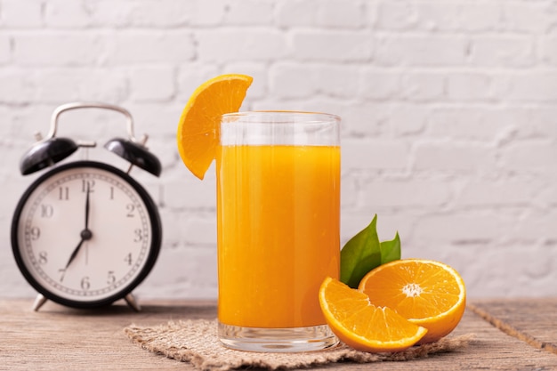 Copo de suco de laranja na mesa de madeira.