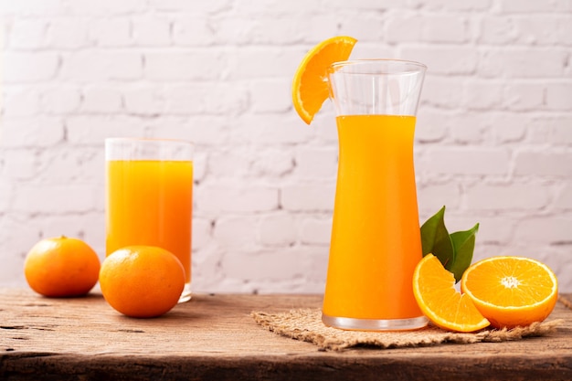 Foto copo de suco de laranja na mesa de madeira.