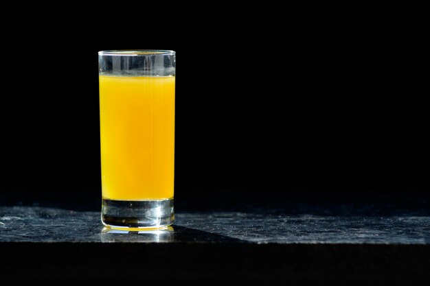 Copo de suco de laranja na mesa na cozinha